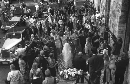 A couple getting married in San Gimignano, Tuscany just minutes after the ceremony leaving the church